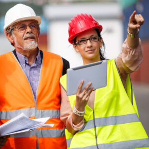 people on factory site looking at tablet